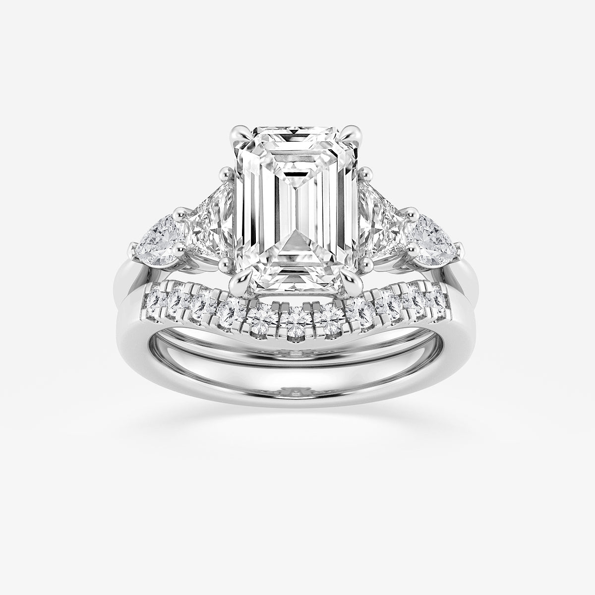 Diamond ring with emerald-cut center stone on a white background