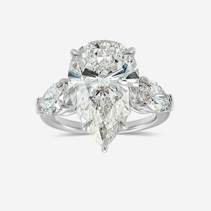 Diamond ring with pear-shaped and round diamonds on a white background