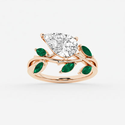 Rose gold ring with a large diamond and green gemstones on a white background