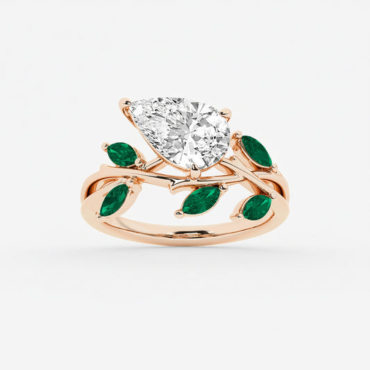 Rose gold ring with a large diamond and green gemstones on a white background