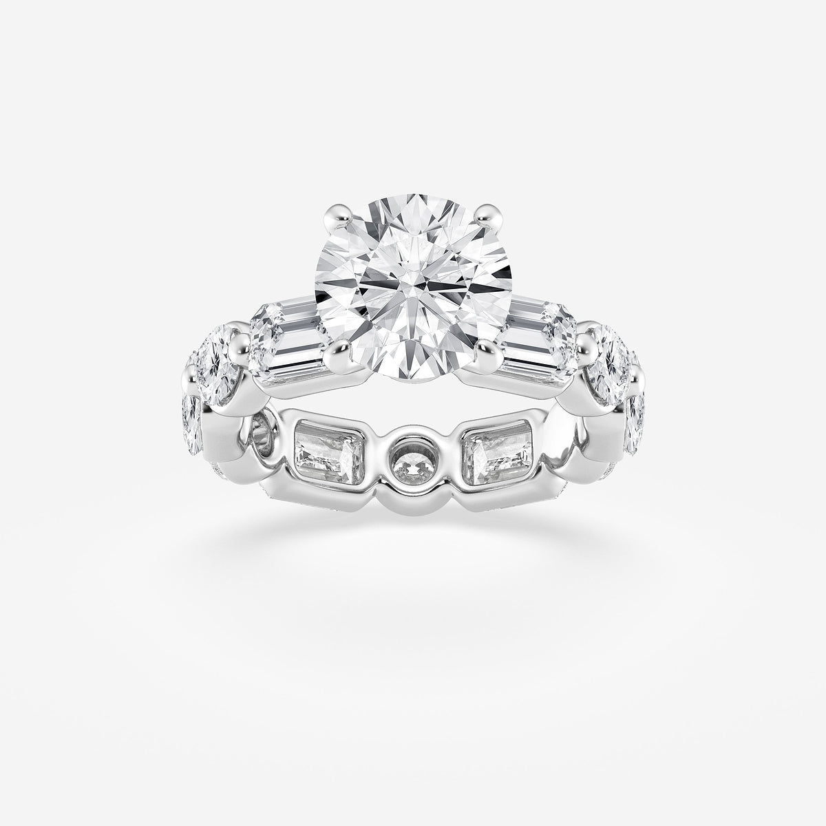 Diamond ring with a central round diamond and side baguette diamonds on a light gray background