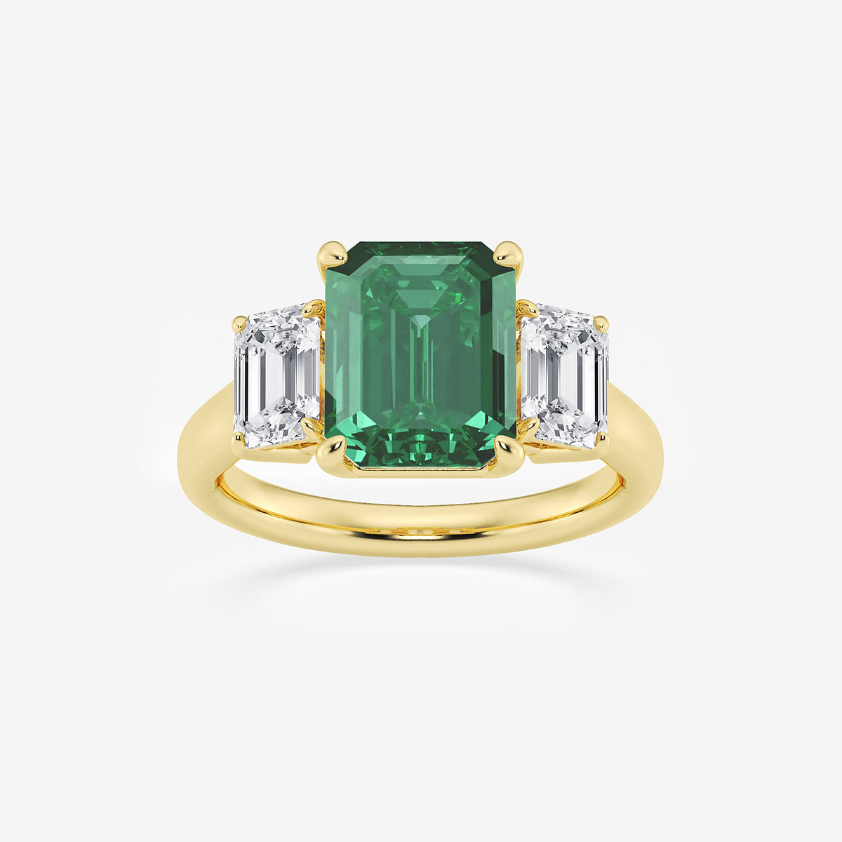 Gold ring with a green emerald and two white diamonds on a light gray background