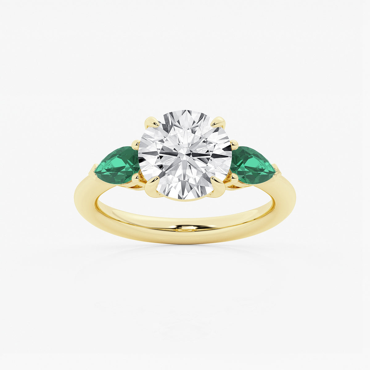 Gold ring with a diamond and emeralds on a white background