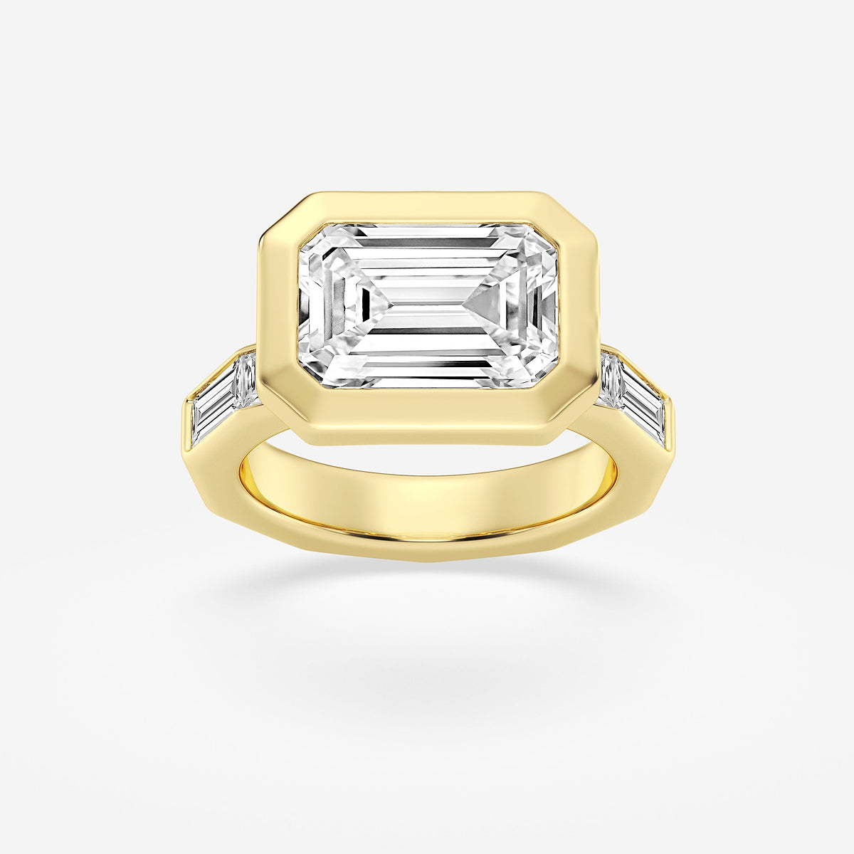 Gold ring with a large emerald-cut diamond and smaller side stones on a white background