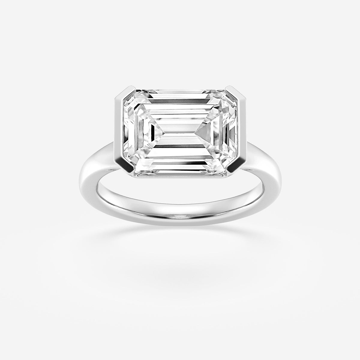 Diamond ring with emerald-cut diamond on a white background