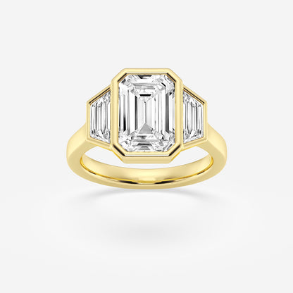 Gold ring with emerald-cut diamond and baguette side stones on a white background